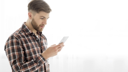 Un giovane uomo guarda il suo cellulare