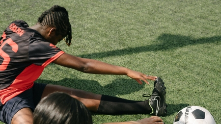 Un calciatore allunga la gamba a terra