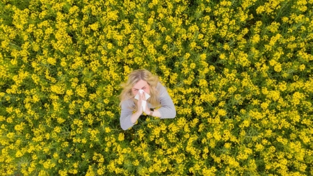 Eine Frau steht im blühenden Feld.