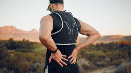 A man is holding his lower back.